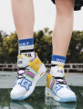 Wielobarwne wysokie buty do koszykówki sznurowane na nogach na boisku sportowym